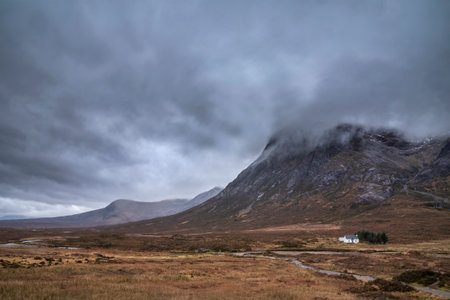 Stunning landscape image view down Glencoe Valley in Scottish Highlands with mountain ranges in dramatic Winter lightingの写真素材