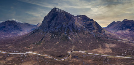 Flying drone dramatic landscape image of Buachaille Etive Mor and surrounding mountains and valleys in Scottish Highlands on a Winter dayの写真素材