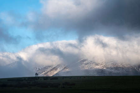 Stunning landscape image of Skiddaw snow capped mountain range in Lake District in Winter with low...