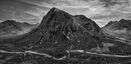 Flying drone dramatic  black and white landscape image of Buachaille Etive Mor and surrounding mountains and valleys in Scottish Highlands on a Winter dayの写真素材