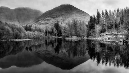 Beautiful  black and white landscape image of Torren Lochan in Glencoe in Scottish Highlands on a Winter dayの写真素材