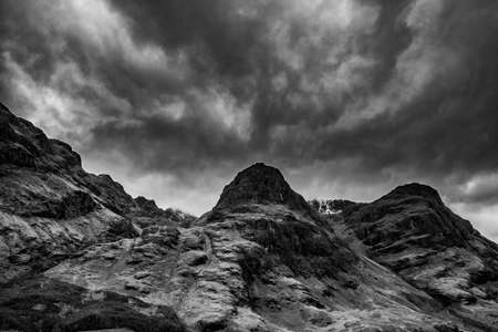 Epic dramatic  black and white landscape image of Three Sisters in Glencoe in Scottish Highlands on a wet Winter dayの写真素材