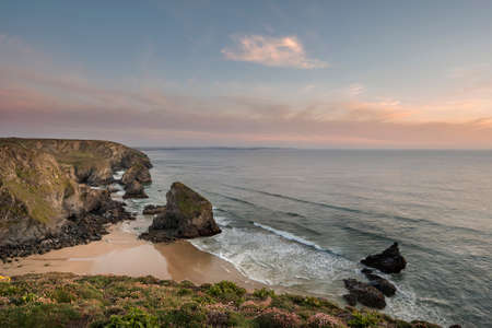 Stunning landscape image during golden hour on Cornwall coastline at Bedruthan Stepsの写真素材