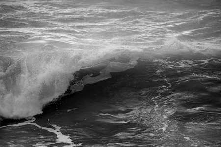 Stunning dark moody toned fine art seascape image of breaking waves on Atlantic Ocean in Devon...