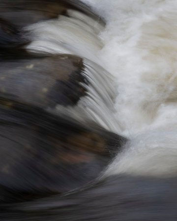 Beautiful fine art landscape image of long exposure detail of fast flowing water over rocks in riverの写真素材