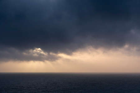 Beautiful fine art landscape image of view from Hartland Quay in Devon England durinbg moody Spring sunsetの写真素材