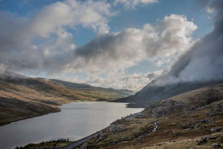 Epic early Autumn Fall landscape of view along Ogwen Valley with Llyn Ogwen and Tryfan under moody evening sky with copy spaceの写真素材