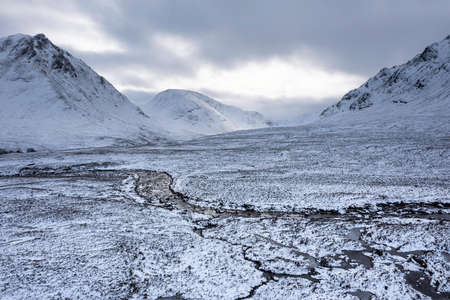 Stunning aerial drone landscape image of Stob Dearg and Glencoe in Scottish Highlands during deep snowfall and beautiful blue skiesの写真素材