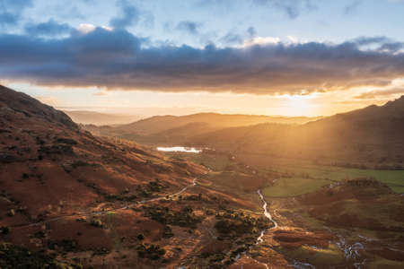 Epic aerial drone landscape image of sunrise from Blea Tarn in Lake District during stunning Autumn showingの写真素材