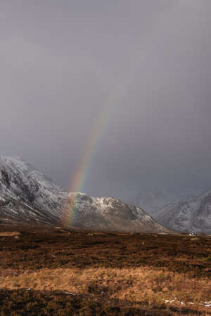 Stunning landscape image of vibrant rainbow in front of mountains in Scottish Highlands Rannoch Moor Stob Deargの写真素材