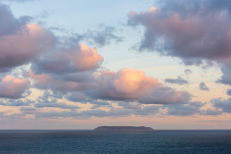 Stunning sunrise clouds formations and colour over Lundy Island on Devonshire coast in England...