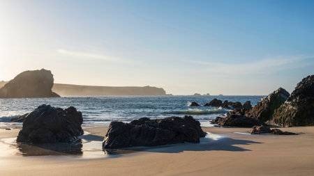 Stunning sunrise over Kynance Cove landscape in Cornwall England with vibrant sky and beautiful turquoise oceanの写真素材
