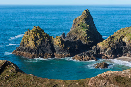 Stunning sunrise over Kynance Cove landscape in Cornwall England with vibrant sky and beautiful turquoise oceanの写真素材