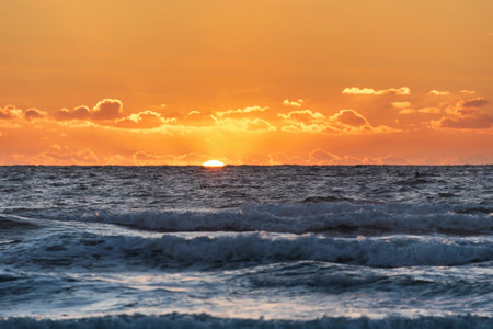 Beautiful Summer sunset landscape image of Widemouth Bay in Devon England with golden hour light ocean with shallow depth of field techniqueの写真素材