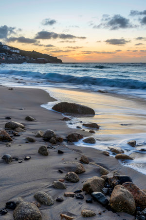 Beautiful landscape of Sennen Cove in Cornwall during sunset with moody sky and long exposure sea motionの写真素材