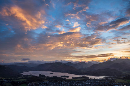 Absolutely stunning landscape image of view across Derwentwater from Latrigg Fell in lake District during Winter beautiful colorful sunsetの写真素材
