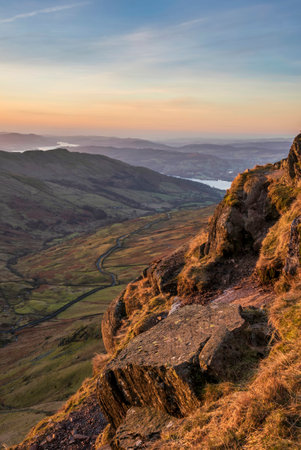 Beautiful Winter dawn landscape view from Red Screes in Lake District looking South towards Windermere with colorful vibrant skyの写真素材