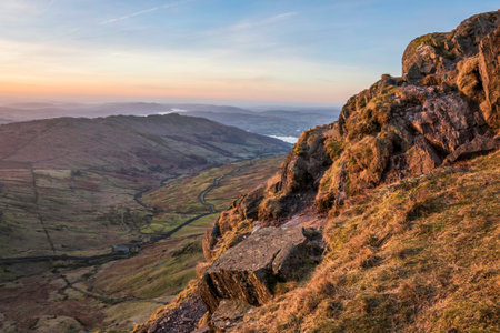 Beautiful Winter dawn landscape view from Red Screes in Lake District looking South towards Windermere with colorful vibrant skyの写真素材