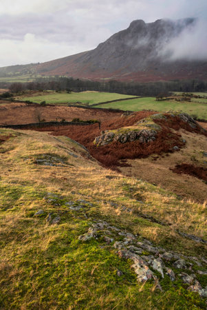 Stunning Winter sunset golden hour landscape image of view from Wast Water over countryside in Lake District towards the Western districtの写真素材