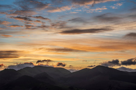 Absolutely stunning landscape image of view across Derwentwater from Latrigg Fell in lake District during Winter beautiful colorful sunsetの写真素材