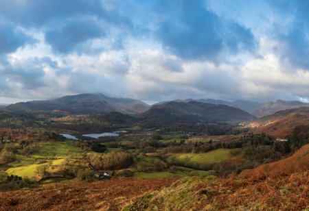 Beautiful Winter sunrise golden hour landscape view from Loughrigg Fell across the countryside towards Langdale Pikes in the Lake Districtの写真素材