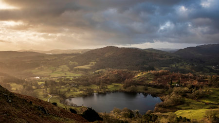 Beautiful Winter sunrise golden hour landscape view from Loughrigg Fell across the countryside in the Lake Districtの写真素材