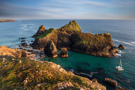 Stunning sunrise and sunset landscape image of popular tourist l;ocation at Kynance Cove in Cornwall England with colourful skyの写真素材