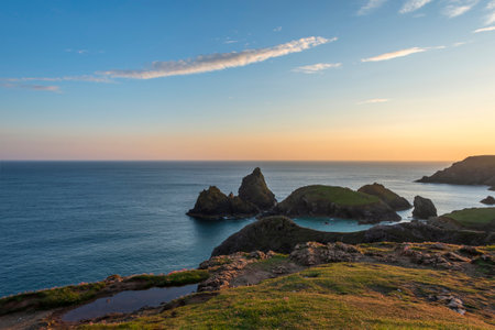 Stunning sunrise and sunset landscape image of popular tourist l;ocation at Kynance Cove in Cornwall England with colourful skyの写真素材