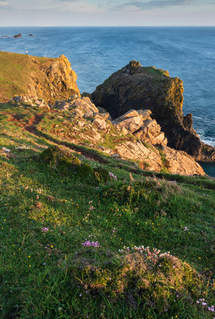 Stunning sunrise and sunset landscape image of popular tourist l;ocation at Kynance Cove in Cornwall England with colourful skyの写真素材