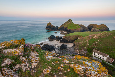 Stunning sunrise and sunset landscape image of popular tourist l;ocation at Kynance Cove in Cornwall England with colourful skyの写真素材