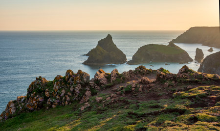 Stunning sunrise and sunset landscape image of popular tourist l;ocation at Kynance Cove in Cornwall England with colourful skyの写真素材