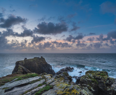 Beautiful dramatic Summer sunrise over Lizard Point in Cornwall UK with lovely glowing sky and...