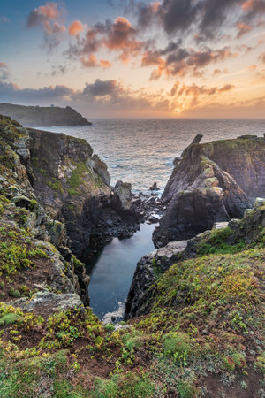 Beautiful dramatic Summer sunrise over Lizard Point in Cornwall UK with lovely glowing sky and cloudsの写真素材
