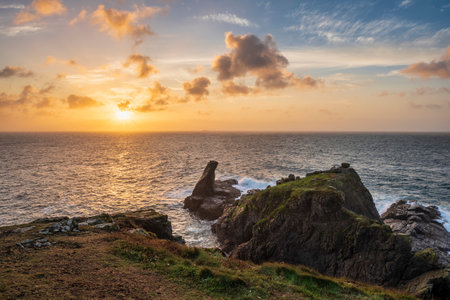 Beautiful dramatic Summer sunrise over Lizard Point in Cornwall UK with lovely glowing sky and cloudsの写真素材