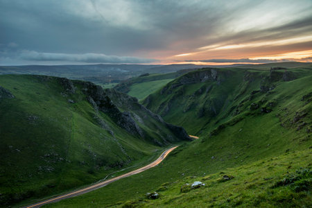 Stunning early Autumn sunrise landscape image viewed along Winnats Pass in Peak District Englandの写真素材