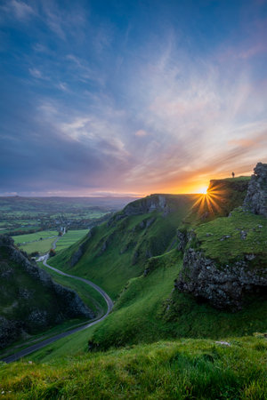 Stunning early Autumn sunrise landscape image viewed along Winnats Pass in Peak District Englandの写真素材