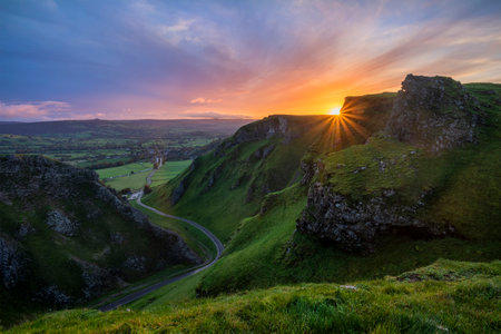 Stunning early Autumn sunrise landscape image viewed along Winnats Pass in Peak District Englandの写真素材