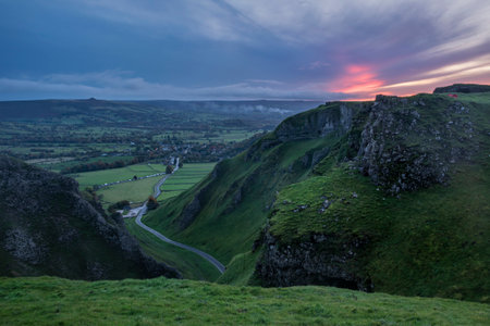 Stunning early Autumn sunrise landscape image viewed along Winnats Pass in Peak District England