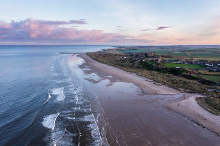 Beautiful aerial drone landscape image of Northumberland beach in Northern England during Winter sunriseの写真素材