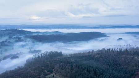 Stunning drone aerial landscape image of cloud inversion around Esthwaite Water in Lake District during Spring sunrise blue hourの写真素材
