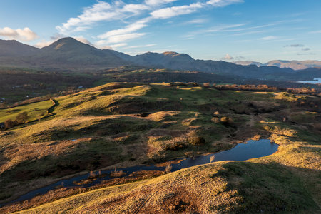 Beautiful Spring sunset landscape aerial drone image in Lake District looking towards Old Man of Conistonの写真素材