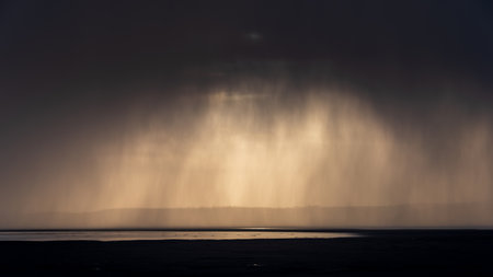 Stunning dramatic stormy skies over ocean landscape with distant heavy rainfallの写真素材