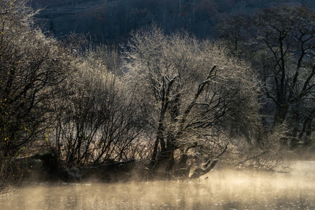 Beautiful Winter morning landscape image of frozen River Rathay in Lake Districtの写真素材