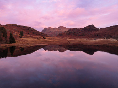 Stunning aerial drone landscape image of Blea Tarn and Langdale Valley in Lake District during vibrant Autumn sunriseの写真素材