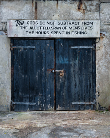 Image of old worn and weathered doors to fishing industry building in docks of Dorsetの写真素材