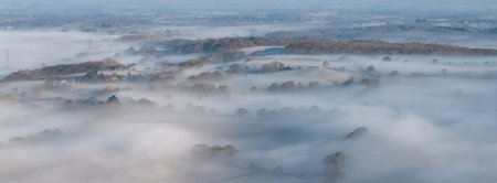 Beautiful aerial drone landscape sunrise image of atmospheric cloud inversion over South Downs escarpmentの写真素材