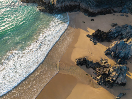 Beautiful aerial drone landscape image of Holywell Bay in Cornwall during vibrant Summer sunsetの写真素材