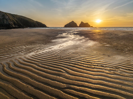 Beautiful aerial drone landscape image of Holywell Bay in Cornwall during vibrant Summer sunsetの写真素材