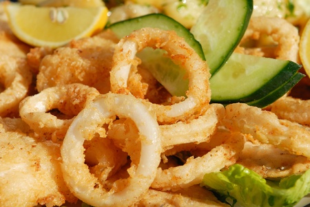 Fried calamari with arugula salad, lemon, and vegetables