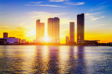 Miami city skyline panorama at dusk with urban skyscrapers over sea with reflection のeditorial素材